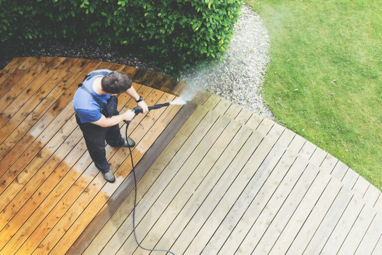 Man pressure washing a deck in Auckland.