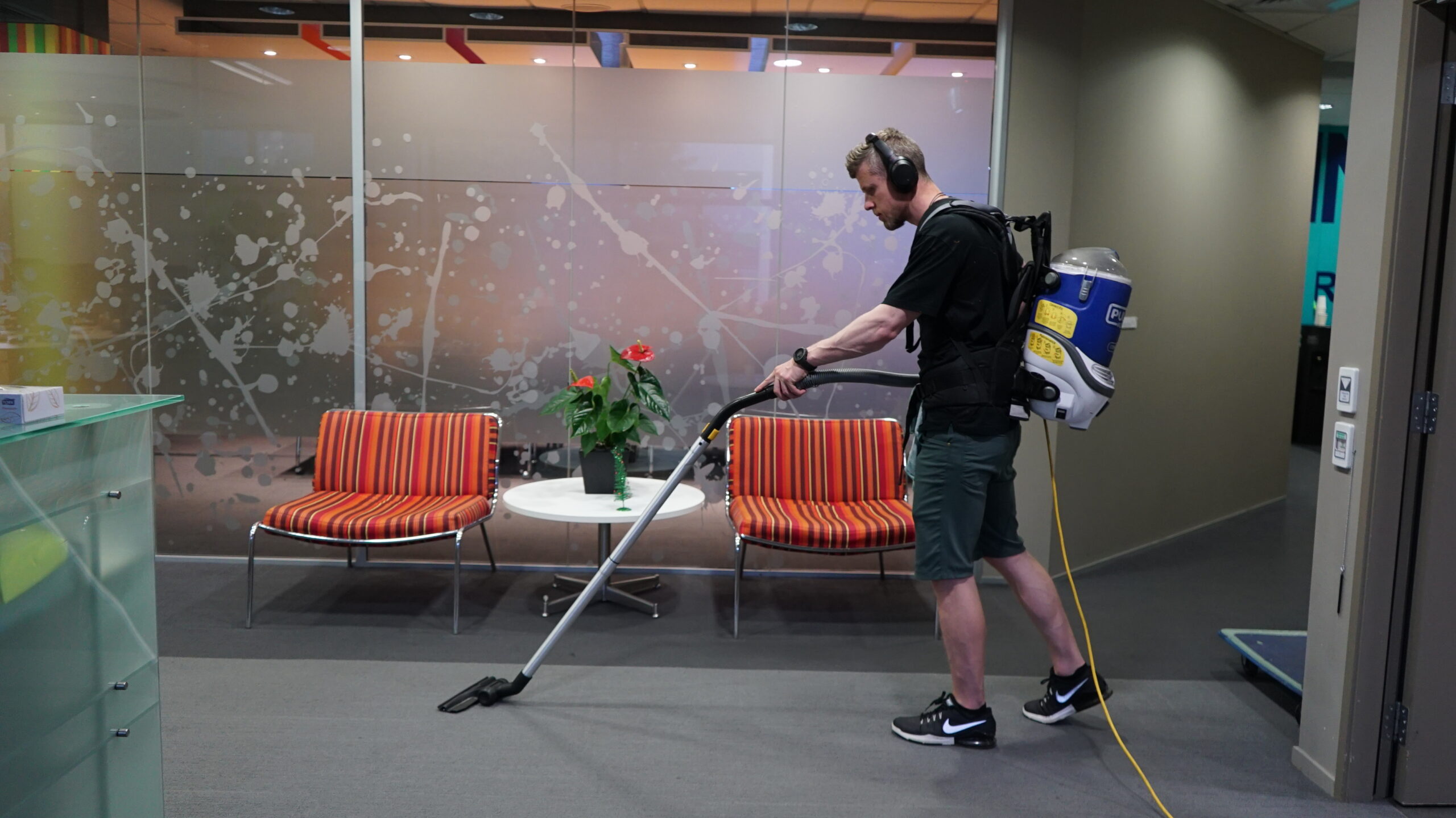 Man is vacuuming office floors.